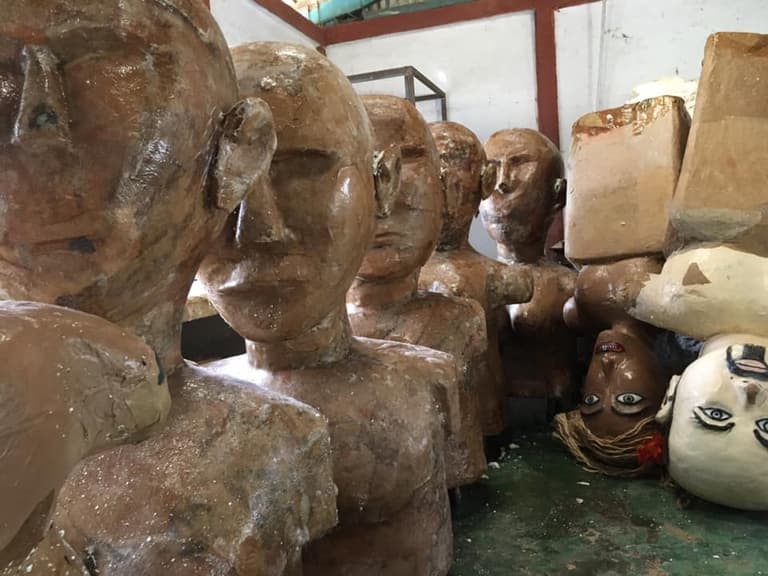 Bustos dos bonecos gigantes em papel machê, guardados na oficina.