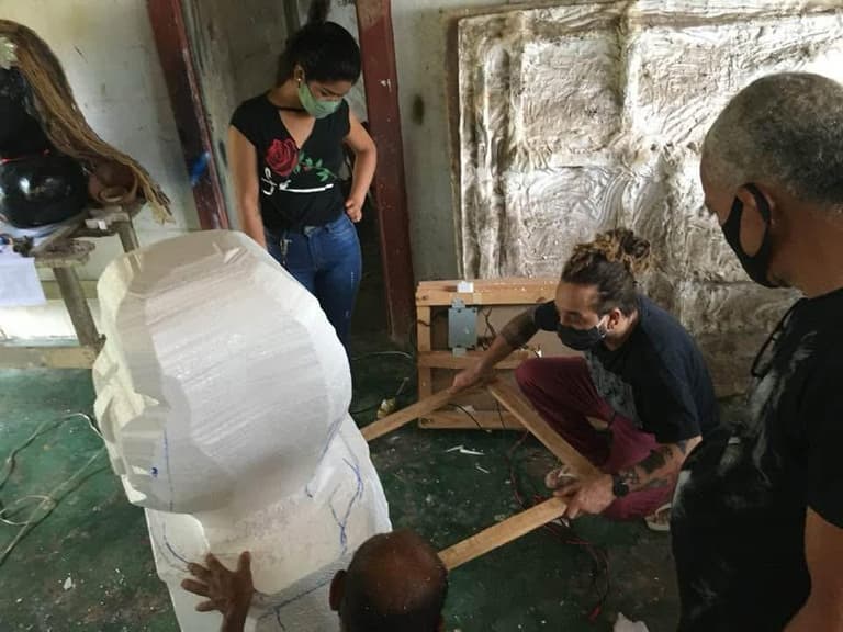 A cabeça de um boneco gigante esculpida à mão na oficina de confecção.